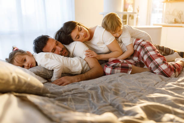 istock Relaxed parents and their kids taking a nap on a bed. 1353963729