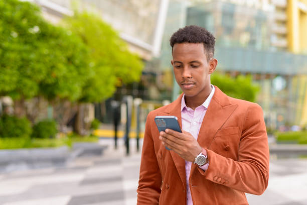istock Portrait African businessman outdoors using mobile phone 1353964263