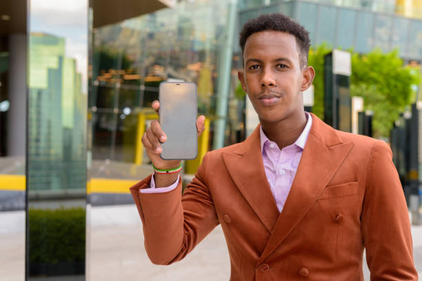 istock African businessman outdoors showing mobile phone with copy space 1353965007