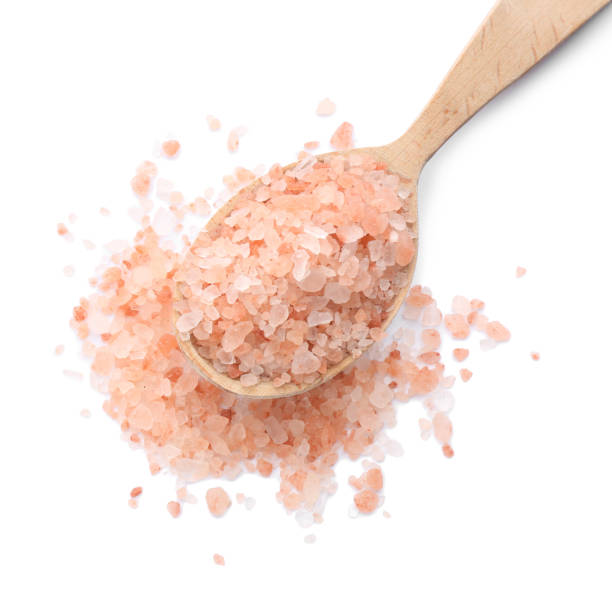 istock Wooden spoon with pink himalayan salt isolated on white, top view 1353965714