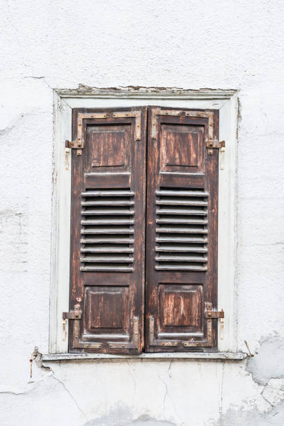 istock Old window with closed wooden shutters, Germany 1353965738