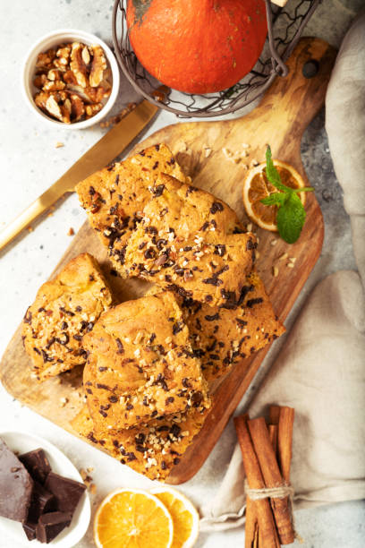 istock Pumpkin blondie bars with chocolate and walnuts top view. Brownie pie slices on a serving wooden board on a light gray culinary background. Baking for Thanksgiving 1353966489