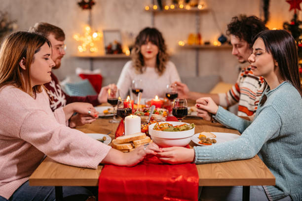 istock Friends prays before eating holiday dinner 1353967352