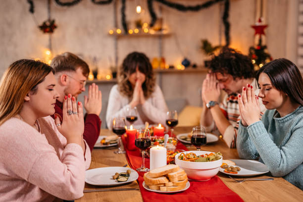 istock Friends prays before eating holiday dinner 1353967381