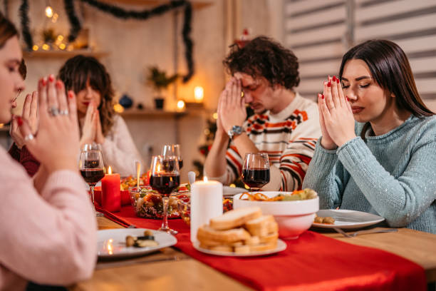 istock Friends prays before eating holiday dinner 1353967527
