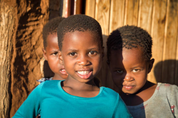 portrait of three African kids in front of their house stock photo