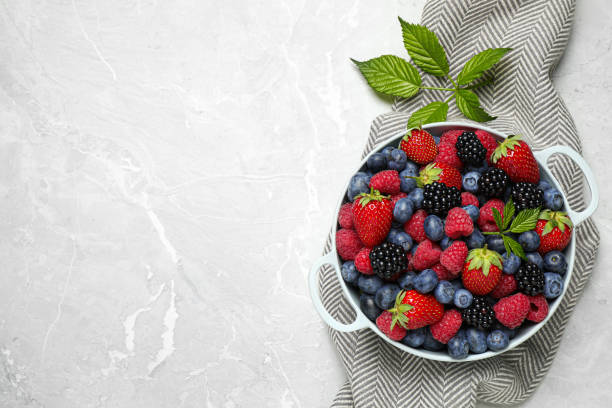 istock Mix of ripe berries on light table, flat lay. Space for text 1353968520