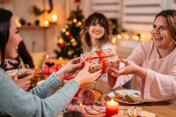 istock Friends exchanging Christmas gifts at dinner 1353968696