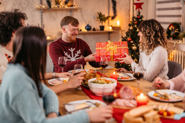 istock Friends exchanging Christmas gifts at dinner 1353968872