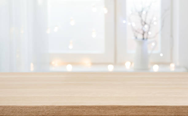 istock Wood table top and defocused window sill holiday lights background 1353968885