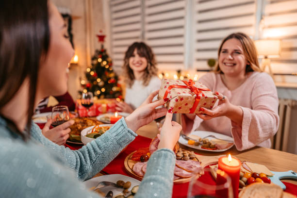 istock Friends exchanging Christmas gifts at dinner 1353969443