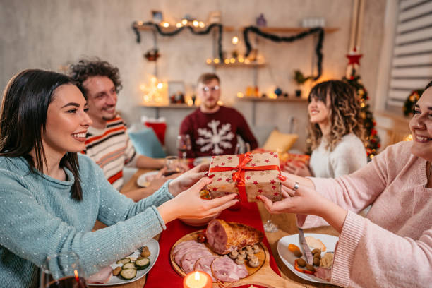 istock Friends exchanging Christmas gifts at dinner 1353969487