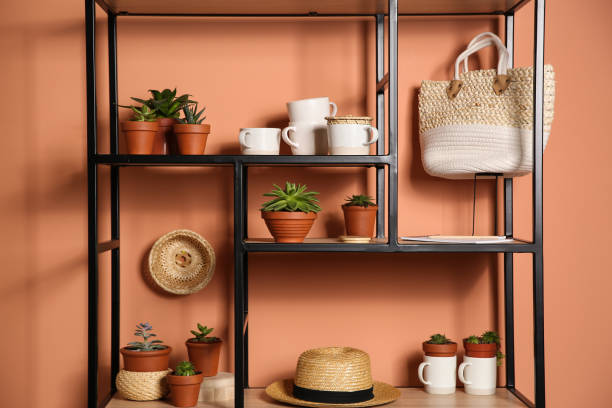 istock Stylish shelving unit with decorative elements near color wall. Interior design 1353969550