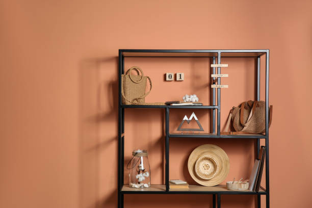 istock Stylish shelving unit with decorative elements near color wall. Space for text 1353969551