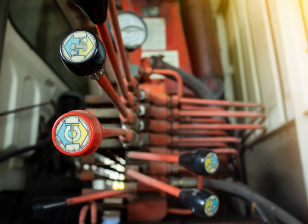 istock Hydraulic tubes, fittings and levers on control 1353969583