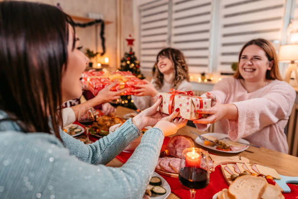 istock Friends exchanging Christmas gifts at dinner 1353969584