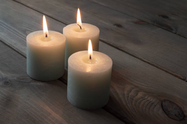 istock Three candles on old wooden background 1353970130