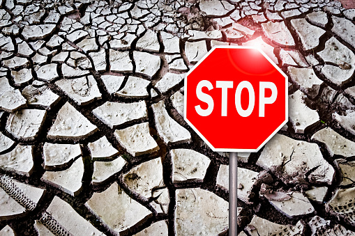 Stop Sign on Cracked Earth as a Symol of Protest Against global warming
