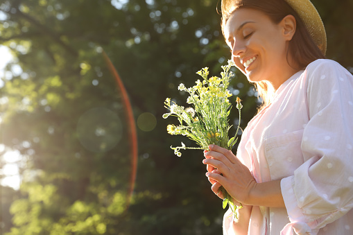 Young woman with beautiful bouquet outdoors on sunny day, space for text