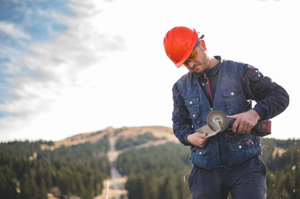 istock Construction worker is cutting lightweight metal, paint coated roofing sheet with an electric angle grinder 1353976121