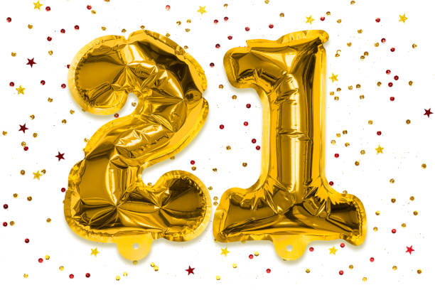 the number of the balloon made of golden foil, the number twenty one on a white background with multicolored sequins. - 21e verjaardag stockfoto's en -beelden