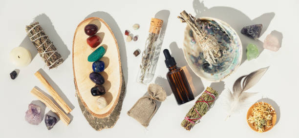 istock Healing crystals, elixir, palo santo, white sage bundle on abalone sea shell, dry healing herbs on white background 1353979909