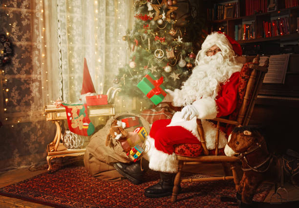 istock Santa Claus leaving presents under the Christmas tree 1353981157