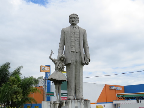 Taubate, Sao Paulo, Brazil - January 3, 2020 - Statue of writer Monteiro Lobato, holding the hand of Emilia, character of his stories, at the entrance of the city of Taubate.