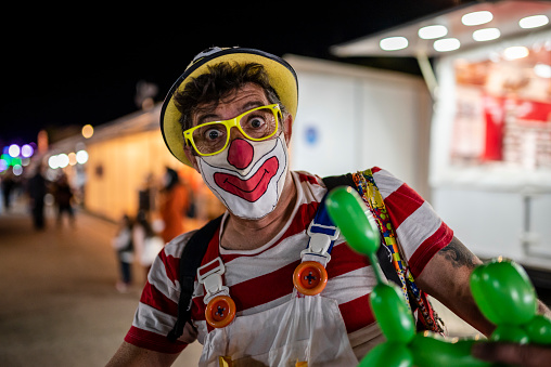 Faro, Portugal - October 22, 2021: The clown entertaining kids during Santa Iria fair in Algarve