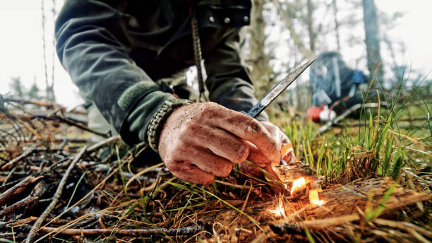 istock Man igniting fire using ferrocerium rod and knife 1353986999