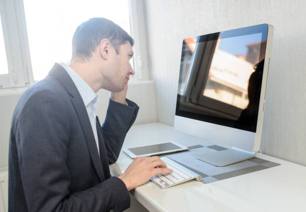 istock young man working on the computer in a light gray room 1353988485