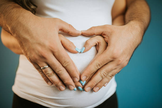 a pregnant woman in a white T-shirt and blue jeans. Close-up of the baby. Dad and mom's hands. Ivf, family, love, family planning, gynecologist, doctor, children. High quality photo