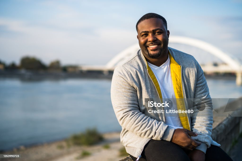 Modern black man resting by the river Happy black man enjoys  resting by the river. Men Stock Photo