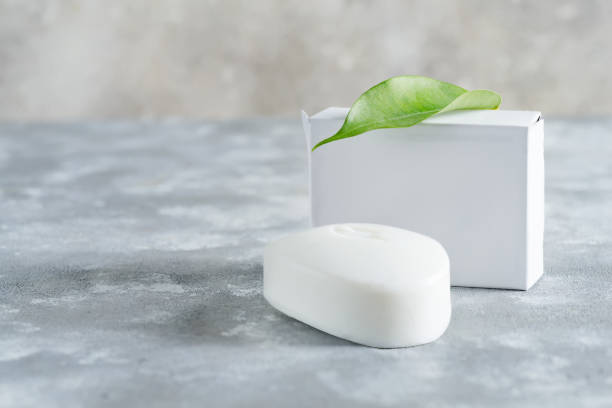 istock White soap for hand with leaf at stone background. Mock up for logo and text. 1353990896