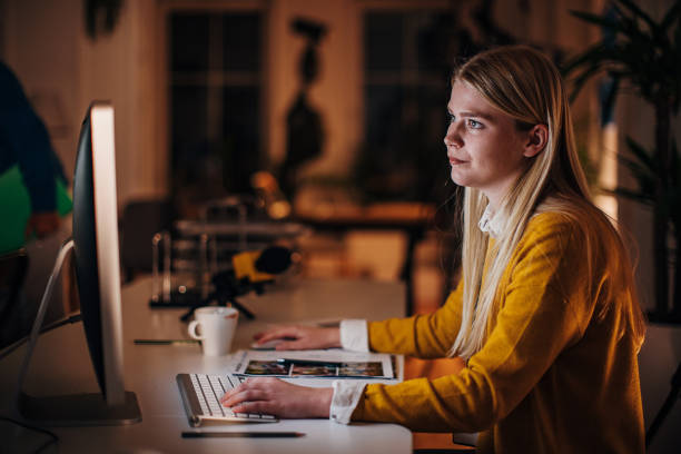 Female journalist working in office One woman, young female journalist working in news editorial office at night. Copyeditor stock pictures, royalty-free photos & images