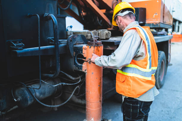istock Mechanic with yellow hardhat inspecting mobile crane 1353994687