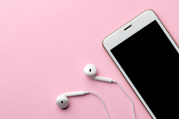 istock White smartphone with headphones on a bright pink background. view from above 1353995627