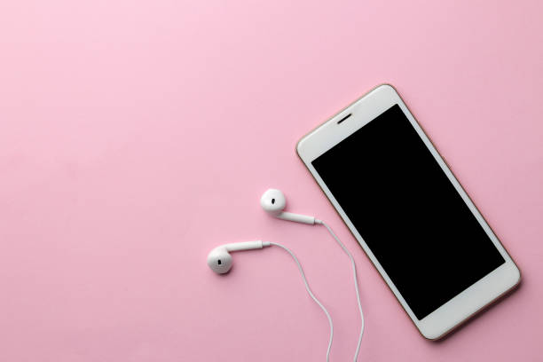 istock White smartphone with headphones on a bright pink background. view from above 1353995634