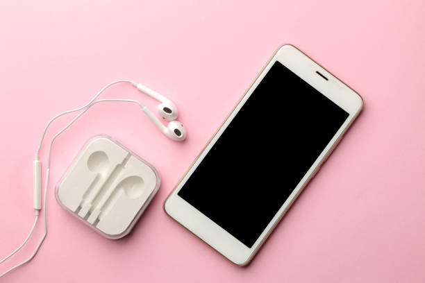 istock White smartphone and headphones on a bright pink background. view from above 1353995635