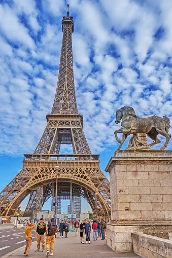 Paris, France - September 30, 2021: Pedestrians go over the Pont d´Lena bridge in Paris. In the background the Eiffel Tower.