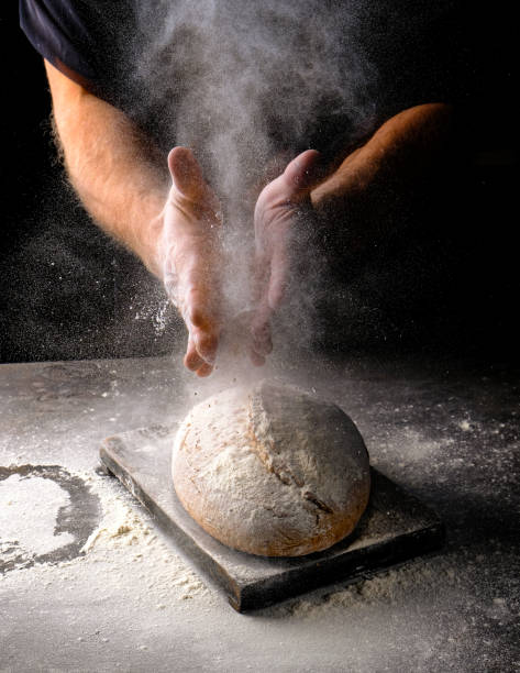 istock Bread with flour, men's hands behind 1353999430