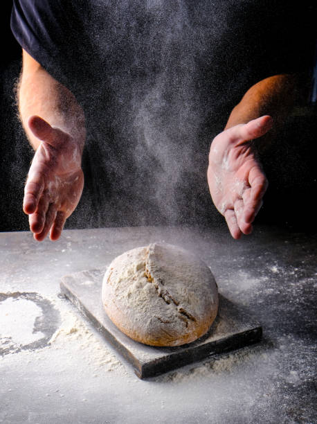 istock A man in a black sweater with bare hands holds a bread wrapped in flour 1353999436