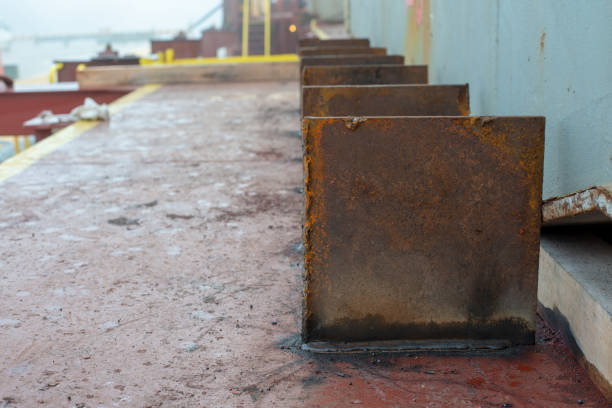 Safe cargo lashing onboard of ship deck with cargo lashing steel stoppers performed by deck crew.
