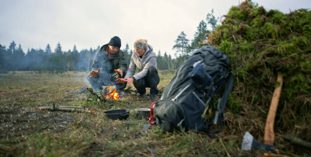 istock Couple sitting near campfire in forest 1354005183