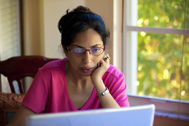 Woman reading on her laptop computer stock photo