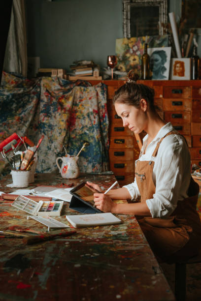 istock Portrait of female artist using tablet for sketching 1354014890