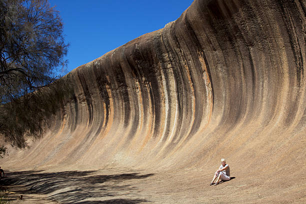 istock Woman sitting beneath awesome Wave Rock formation 135401518