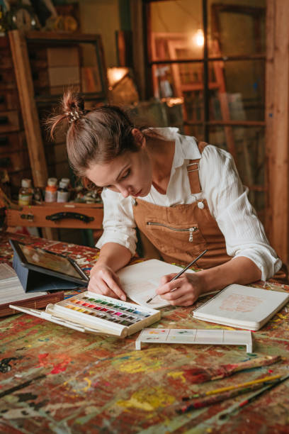 istock Young artist concentrating on drawing process at art studio 1354015281