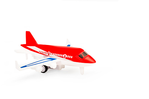 A red toy plane on a white background with copy space