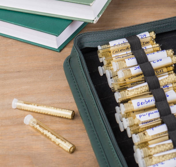 istock Homeopathy globules and vials on a table with books and folder 1354019476